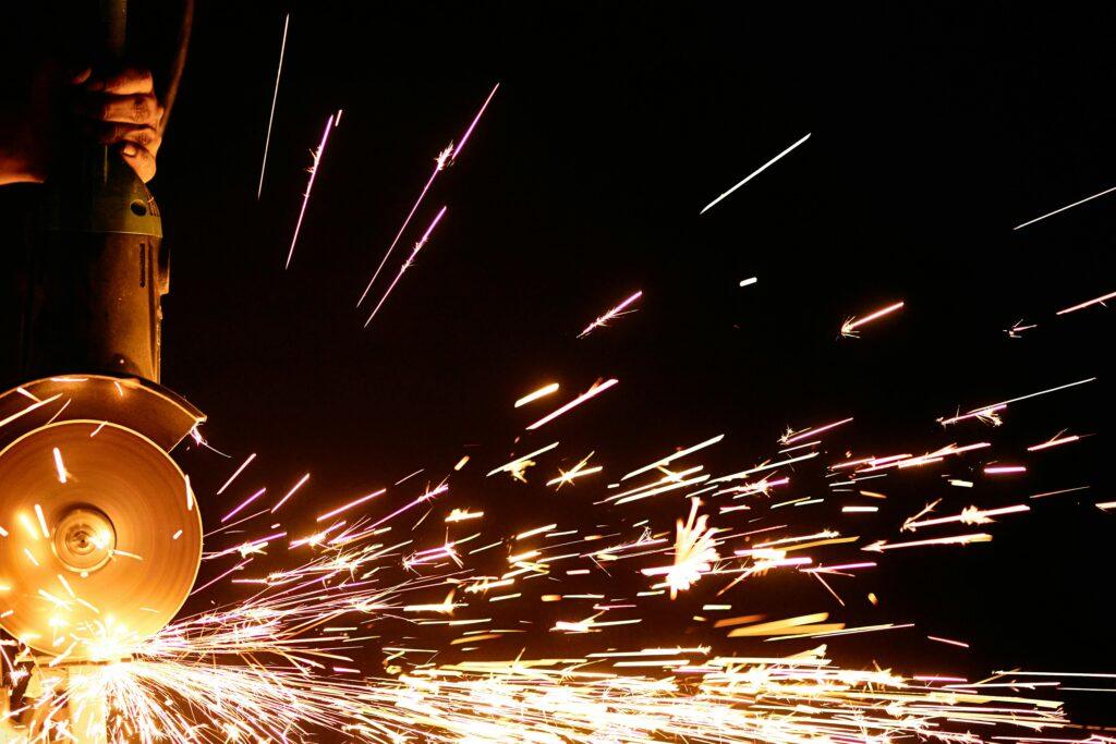 Dynamic image of sparks flying from a power tool in a dark setting, capturing intense energy.